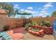 Cozy private patio with brick pavers, colorful garden area, and an umbrella for shade at 7977 W Wacker Rd # 134, Peoria, AZ 85381