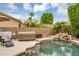 Beautiful backyard features a pool with a waterfall, hot tub, and lush landscaping at 8531 E Natal Cir, Mesa, AZ 85209