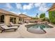Lounge chairs line this beautiful backyard pool, complimented by mature landscaping and blue skies at 8531 E Natal Cir, Mesa, AZ 85209