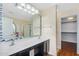 Bright bathroom features a double vanity, decorative mirror and an open walk-in closet at 8531 E Natal Cir, Mesa, AZ 85209