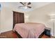 Neutral bedroom boasts laminated floors, ceiling fan, and dimming bedside lamps at 8531 E Natal Cir, Mesa, AZ 85209