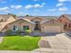 Well-maintained one-story home featuring desert landscaping, a green lawn, and a two-car garage at 8531 E Natal Cir, Mesa, AZ 85209