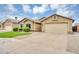 Single-story home with desert landscaping, green lawn, and attached two-car garage at 8531 E Natal Cir, Mesa, AZ 85209