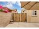 Wooden privacy gate surrounded by beautiful pink bougainvillea in a sunny backyard at 8531 E Natal Cir, Mesa, AZ 85209
