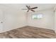 Spacious bedroom with wood-look flooring, ceiling fan, and a window allowing natural light to fill the room at 900 S Palo Verde Dr, Apache Junction, AZ 85120