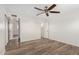 Bright bedroom with wood-look floors, a ceiling fan, and access to the bathroom at 900 S Palo Verde Dr, Apache Junction, AZ 85120