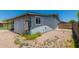 Exterior side view of home with neutral-colored walls, a window, and a gate leading to the backyard at 900 S Palo Verde Dr, Apache Junction, AZ 85120