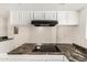 Bright kitchen featuring granite countertops, white cabinetry, and a modern electric cooktop at 900 S Palo Verde Dr, Apache Junction, AZ 85120