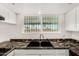 Updated kitchen showcasing a black sink and faucet, complemented by white cabinets and granite counters at 900 S Palo Verde Dr, Apache Junction, AZ 85120