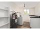 Well lit laundry room with a washing machine, dryer, water heater, and storage shelves at 900 S Palo Verde Dr, Apache Junction, AZ 85120