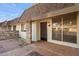 Inviting covered front porch with brick accents, tiled flooring, and a stylish entrance door at 9613 W Shasta Dr, Sun City, AZ 85351