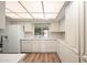 Bright kitchen with white appliances and cabinets, complemented by modern flooring at 9613 W Shasta Dr, Sun City, AZ 85351