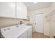 Functional laundry room with washer, dryer, sink, and storage cabinets above at 9613 W Shasta Dr, Sun City, AZ 85351