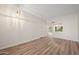 Spacious living room with updated floors, a modern light fixture, and a pass-through to the other room at 9613 W Shasta Dr, Sun City, AZ 85351