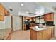 Well-lit kitchen featuring wooden cabinets, tile floors, granite countertops, and modern appliances at 9645 W Kimberly Way, Peoria, AZ 85382