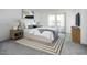 Bright main bedroom featuring a large bed, neutral decor, and a large window that lets in natural light at 9851 W Agora Ln, Tolleson, AZ 85353