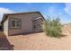 Backyard showcasing the home's exterior, with desert landscaping and a bay window adding charm at 10442 W Toronto Way, Tolleson, AZ 85353