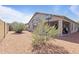Landscaped backyard with desert features, covered patio, and outdoor basketball hoop for recreation at 10442 W Toronto Way, Tolleson, AZ 85353