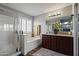 Bright bathroom featuring a soaking tub, glass shower, and a modern vanity with granite countertops at 10442 W Toronto Way, Tolleson, AZ 85353