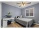 Comfortable bedroom with a window, ceiling fan, wood-style floors, and a desk at 10442 W Toronto Way, Tolleson, AZ 85353