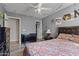 This bedroom is decorated with a ceiling fan, hardwood floors and a desk at 10442 W Toronto Way, Tolleson, AZ 85353