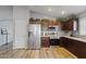 Well-lit kitchen with stainless steel appliances, dark cabinets, and granite countertops at 10442 W Toronto Way, Tolleson, AZ 85353