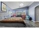 Bright primary bedroom with seating area, soft carpet, and blue accent walls at 10442 W Toronto Way, Tolleson, AZ 85353