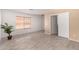 Spacious bedroom with wood-look tile flooring, neutral walls, and a window for natural light at 12132 W Dahlia Dr, El Mirage, AZ 85335