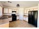 Well-lit kitchen with ample cabinetry, laminate countertops, and black appliances including a range and refrigerator at 12132 W Dahlia Dr, El Mirage, AZ 85335