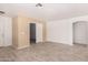 Open living room featuring neutral walls, wood-look tile floors, and convenient access to other rooms at 12132 W Dahlia Dr, El Mirage, AZ 85335
