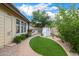 Landscaped backyard with artificial turf, brick walkways, stone fireplace, and outdoor kitchen creates a peaceful retreat at 122 W Cottage Ln, Tempe, AZ 85282