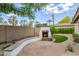 Private backyard featuring a stone fireplace, brick patio, mature landscaping, seating, and ample space for entertaining at 122 W Cottage Ln, Tempe, AZ 85282