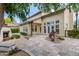 Charming backyard with stone patio, lush plants, manicured landscaping, outdoor lighting, and a cozy fireplace at 122 W Cottage Ln, Tempe, AZ 85282