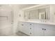 Bathroom with dual sinks, white cabinets and mirror that reflects doorway at 122 W Cottage Ln, Tempe, AZ 85282