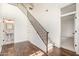 Bright entryway featuring hardwood floors, staircase with metal railing, and views into the powder room and another room at 122 W Cottage Ln, Tempe, AZ 85282