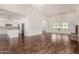Spacious living area with wood floors, a stone fireplace, and an open kitchen with white cabinets at 122 W Cottage Ln, Tempe, AZ 85282