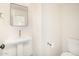 Elegant powder room featuring pedestal sink, gold faucet, rectangular mirror, and crisp white walls at 122 W Cottage Ln, Tempe, AZ 85282