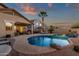 Inviting backyard pool with a rock feature and adjacent covered patio, perfect for outdoor relaxation and entertainment at 20848 E Desert Hills Blvd, Queen Creek, AZ 85142
