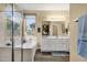 Bathroom features a vanity with double sinks, walk-in shower, and a soaking tub under a large window at 20848 E Desert Hills Blvd, Queen Creek, AZ 85142