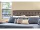 Comfortable bedroom with a large headboard, decorative pillows and large window view to the outdoors at 20848 E Desert Hills Blvd, Queen Creek, AZ 85142