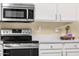 Close up view of stainless steel oven, microwave and quartz counters with white cabinets at 20848 E Desert Hills Blvd, Queen Creek, AZ 85142