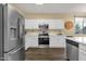 Modern kitchen features stainless steel appliances, white cabinetry, and quartz countertops at 20848 E Desert Hills Blvd, Queen Creek, AZ 85142