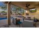Inviting covered patio with outdoor seating, TV, and pool view perfect for relaxation and enjoyment at 20848 E Desert Hills Blvd, Queen Creek, AZ 85142