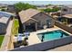 Inviting backyard with a sparkling pool, lounge area, BBQ, and a well-manicured yard offers ideal outdoor enjoyment at 26232 N 121St Ln, Peoria, AZ 85383