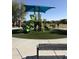 Community playground featuring a green slide, awning, and picnic tables on a sunny day at 26232 N 121St Ln, Peoria, AZ 85383