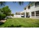 Expansive backyard featuring lush lawn, patio with seating, and mature landscaping perfect for outdoor entertaining at 4454 S Lariat Ct, Gilbert, AZ 85297