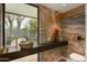 Stylish bathroom features a vessel sink, custom wallpaper, and a large window with a view of lush greenery at 5311 E Mitchell Dr, Phoenix, AZ 85018