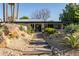 Modern home featuring desert-style landscaping, natural rock features, and a pathway leading to the entrance at 5311 E Mitchell Dr, Phoenix, AZ 85018