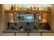 A kitchen bar features dark countertops and a wood backsplash, complemented by a view to a backyard patio at 5311 E Mitchell Dr, Phoenix, AZ 85018