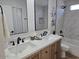 Modern bathroom with double vanity, updated fixtures, and marble-look tile on the shower walls at 6607 S Mitchell Dr, Tempe, AZ 85283